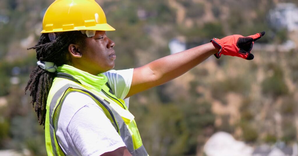 black female engineer outdoors pointing ahead wearing safety gear
